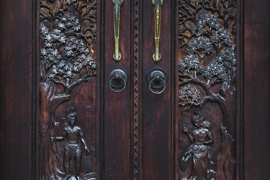 Handmade wooden carving door. Vintage old furniture in Bali style.