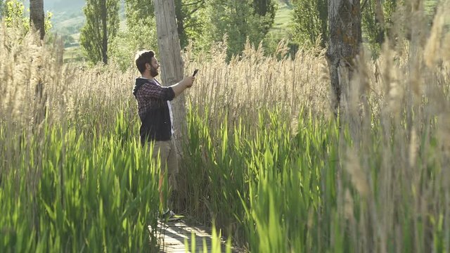 Hiker with digital tablet PC in nature - bulrush taking photos