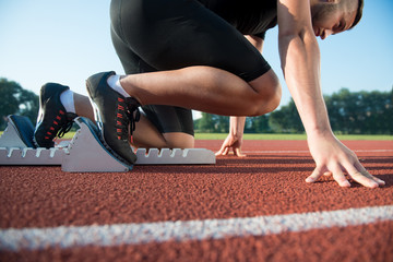 Runners preparing for race at starting blocks