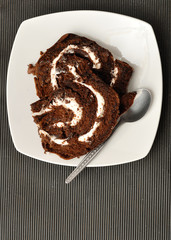 Chocolate swiss roll displayed on a white plate