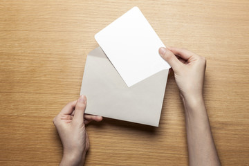 woman hand hold a envelope and letter on the wood table.