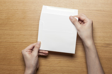 woman hand hold a letter and envelope on the wood table.