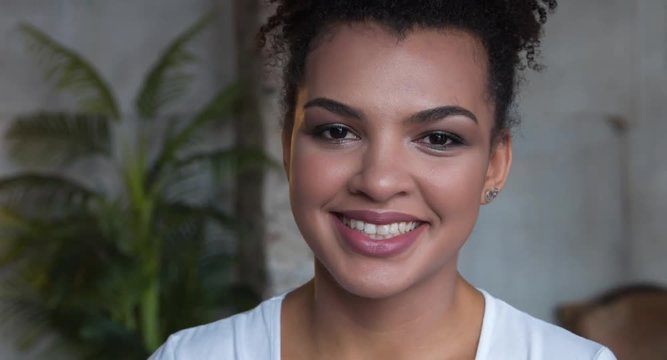 Portrait of attractive smiling African-american woman with make up.