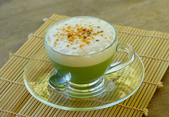 Matcha green tea latte on wooden table background
