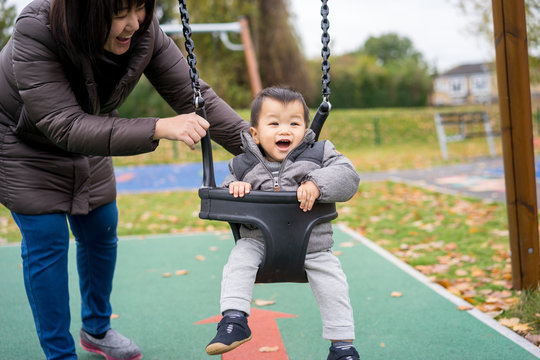 Baby and mother paly swing in the park