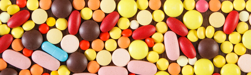 Fototapeta na wymiar Colorful medical pills and capsules as background, health care concept