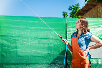 Woman watering the garden with hose