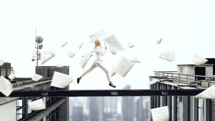 Businesswoman overcoming gap between roofs. Mixed media