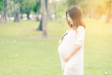 beautiful and happy pregnant asian woman in the garden