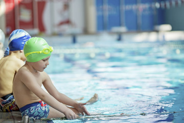 happy children kids group at swimming pool class learning to swim