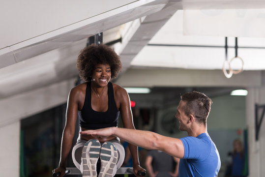 black woman doing parallel bars Exercise with trainer