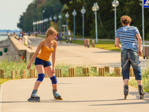 Young couple on roller skates riding outdoors