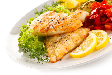 Fried fish cod with vegetables on white background