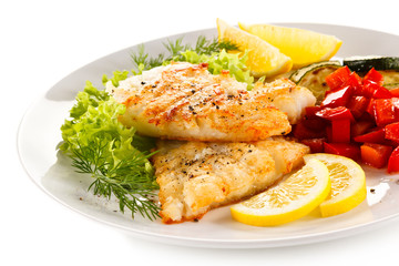 Fried fish cod with vegetables on white background