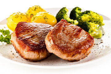 Grilled beefsteak with potatoes and broccoli on white background