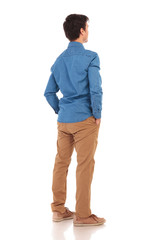 Fototapeta premium back view of a casual man with hands in pockets