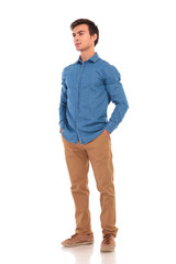 side  of a relaxed casual man with hands in pockets