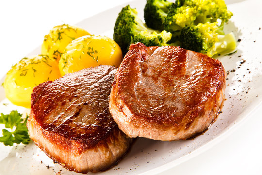 Grilled beefsteak with potatoes and broccoli on white background