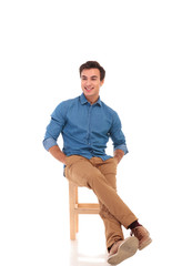 full body picture of relaxed seated man looking to side