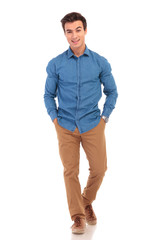 Fototapeta premium happy young casual man with hands in pockets smiling