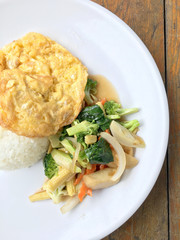 Vegetable stir fry with Omelette  in a white plate on wooden background. Thai style food. Vegetarian Food