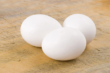 Three eggs on old wooden background