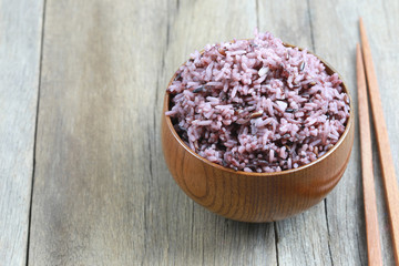 Organic Rice berry in wooden dish on wood background.