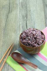 Organic Rice berry in wooden dish on wood background.