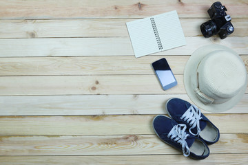 Holiday travel equipment on wooden floor background.