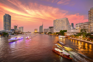 Bangkok city with business building and chao praya river with boat at twilight sunset, street view on Taksin Bridge, thailand.