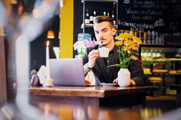 A man drinks coffee in a cafe.