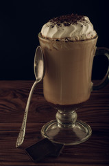 Hot viennese coffee with whipped cream on dark background