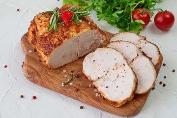 Roasted chicken breast for sandwiches on a wooden cutting board on a white abstract background. Easy food. Healthy eating concept