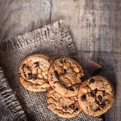 Chocolate cookies on dark  napkin on wooden table. Closeup of a group of assorted cookies..
