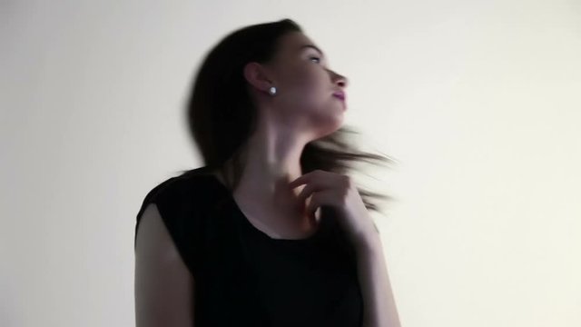 A woman holds her fingers over the face, neck, collarbone