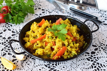 Vegetarian rice with carrots, onions, raisans and olive oil in a black metal bowl. healthy eating concept. Dieting