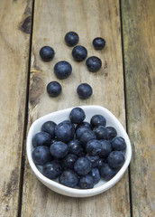 Freshly picked blueberries in wooden bowl. Juicy and fresh blueberries on rustic table