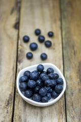 Freshly picked blueberries in wooden bowl. Juicy and fresh blueberries on rustic table