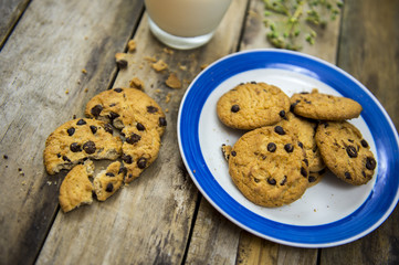 Glass of milk and cookies on wooden table. Top view