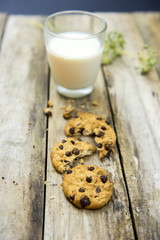 Glass of milk and cookies on wooden table. Top view