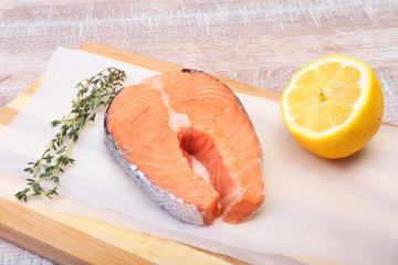 fresh raw salmon with spices and lemon on wooden cutting board. ready for cookin