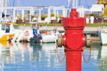 Red fire hydrant in a harbor - concept image with copy space