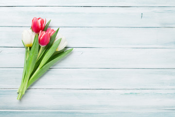 Colorful tulips over wooden background