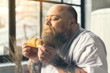 Hungry man smelling croissant - Powered by Adobe