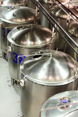 Several glossy steel cylindrical tanks with semicircular covers.
