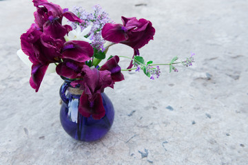 Spring bouquet in a blue vase on a concrete background