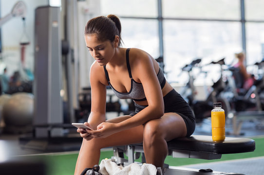 Woman Using Phone At Gym