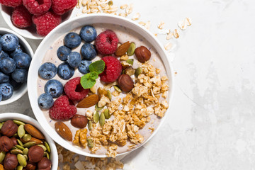muesli with yogurt and berries for breakfast on white background, closeup top view