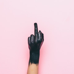 hand shows aggressive gesture with the middle finger. fuck you concept. minimal style.