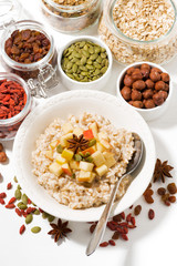 oatmeal with apples, dried fruit and nuts, vertical top view